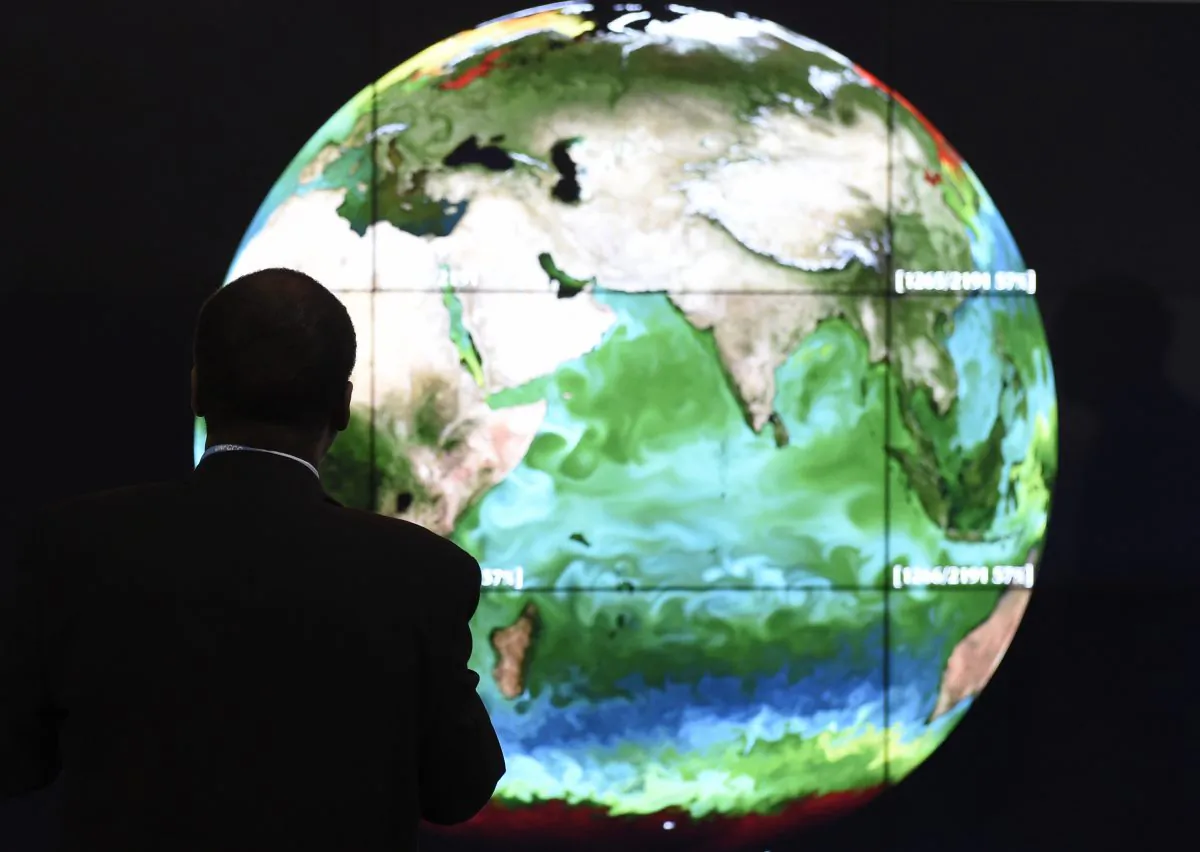 A conference attendee looks at a projection of the Earth on the opening day of the COP 21 U.N. conference on climate change in Le Bourget, on the outskirts of the French capital Paris, on Nov. 30, 2015. (Alain Jocard/AFP/Getty Images)