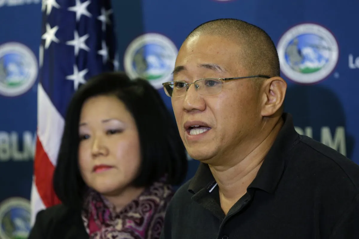 Kenneth Bae, right, who had been held in North Korea since 2012, talks to reporters after he arrived Saturday, Nov. 8, 2014, at Joint Base Lewis-McChord, Wash., after he was freed during a top-secret mission. At left is his sister Terri Chung. (AP Photo/Ted S. Warren)