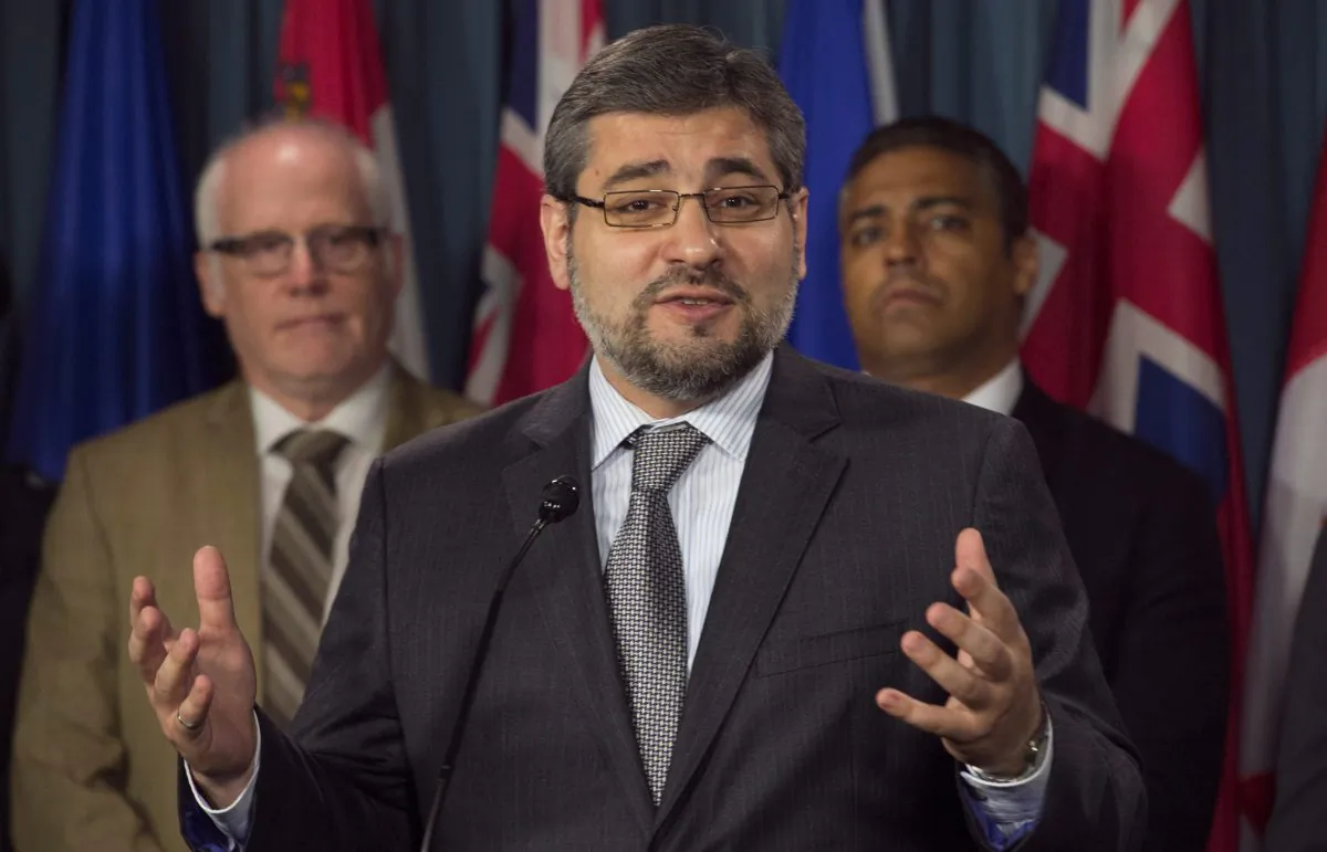 Abdullah Almalki speaks during a press conference in Ottawa on May 3. Standing behind him are Journalist Mohamed Fahmy and Amnesty International Canada Secretary General Alex Neve. (The Canadian Press/Adrian Wyld)
