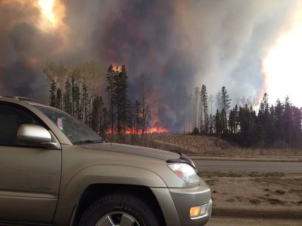 Smoke fills the air and trees burn in Fort McMurray on May 3, 2016. (The Canadian Press/Kitty Cochrane)