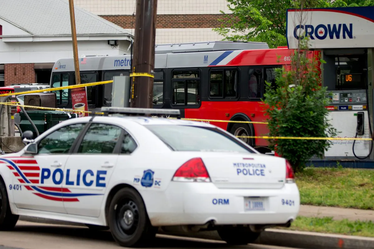 Police work at a crime scene after authorities say a man attacked a bus driver, stole the bus, then struck and killed a man after the bus jumped a curb at a gas station at the corner of Helen Burroughs Avenue and Minnesota Avenue in Northeast Washington, Tuesday, May 3, 2016. (AP Photo/Andrew Harnik)