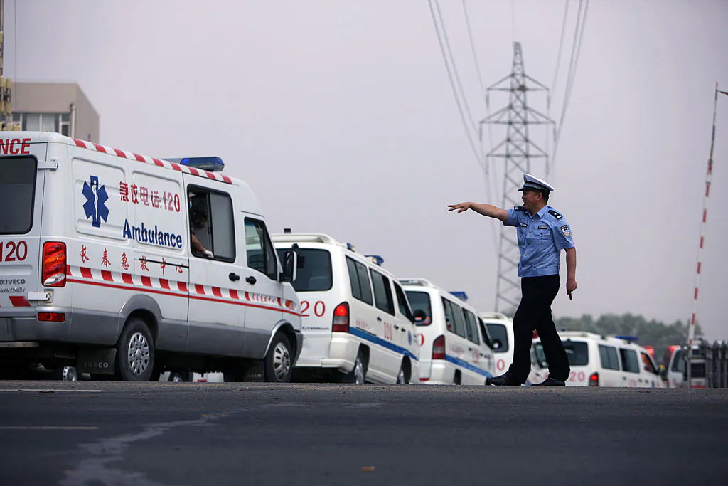 A police officer waves to an ambulance in Dehui, China’s Jilin Province, on June 3, 2013. Rogue operators of unofficial ambulances have become a big problem in China. (STR/AFP/Getty Images)
