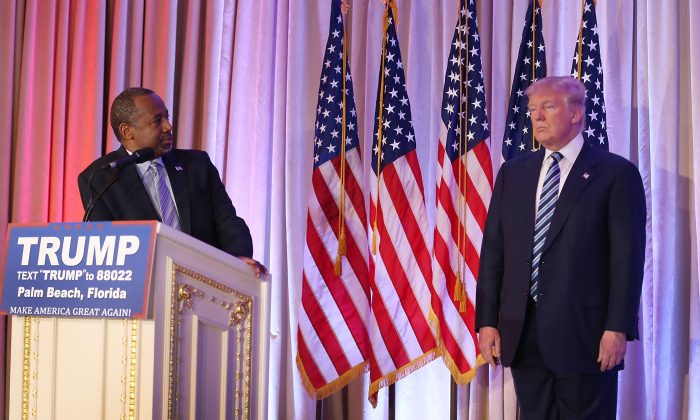 Former Republican presidential candidate Ben Carson looks back at Republican presidential candidate Donald Trump as he give him his endorsement at the Mar-A-Lago Club on March 11, 2016 in Palm Beach, Florida. (Photo by Joe Raedle/Getty Images)