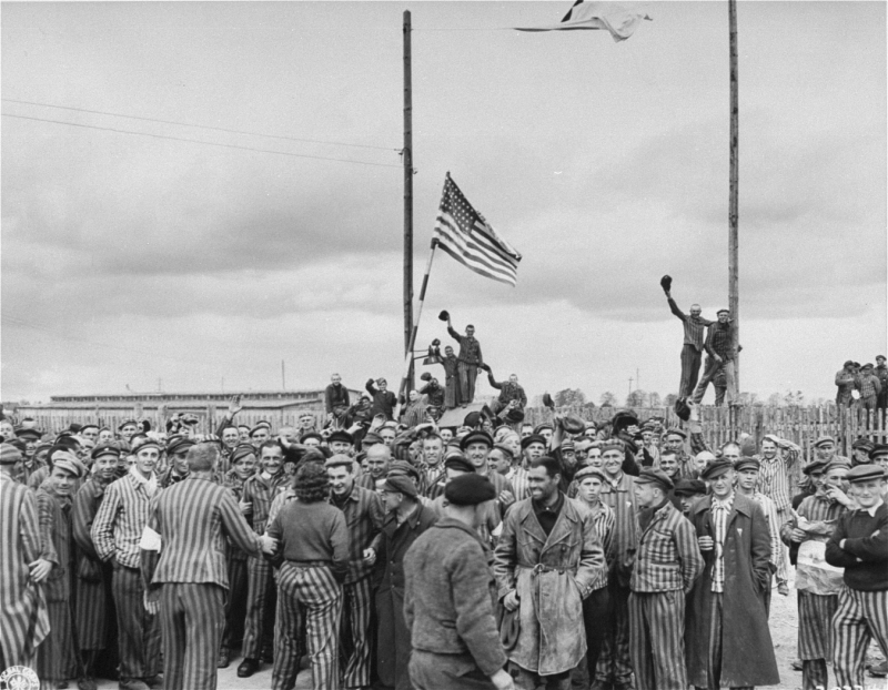 Inmates waving a home-made American flag greet U.S. Seventh Army troops upon their arrival at the Allach concentration camp on April 30, 1945. (Arland B. Musser/U.S. Holocaust Memorial Museum, Courtesy of National Archives and Records Administration, College Park)