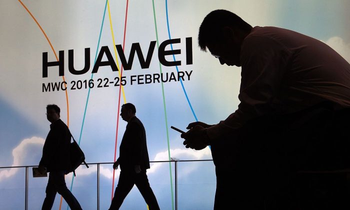 A man uses a mobile phone next to the stand of Chinese telecommunications company Huawei in Barcelona, on Feb. 22, 2016. The company has been widely accused of being a threat to national security. (Lluis Gene/AFP/Getty Images)