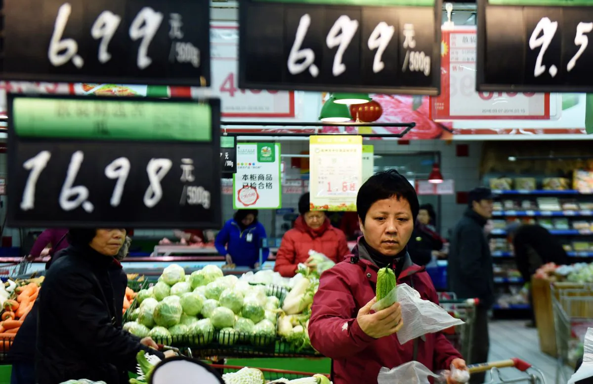 A customer selects vegetables at a supermarket in Hangzhou, in eastern China's Zhejiang province on March 10, 2016. (STR/AFP/Getty Images)