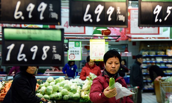 A customer selects vegetables at a supermarket in Hangzhou, in eastern China's Zhejiang province on March 10, 2016. (STR/AFP/Getty Images)