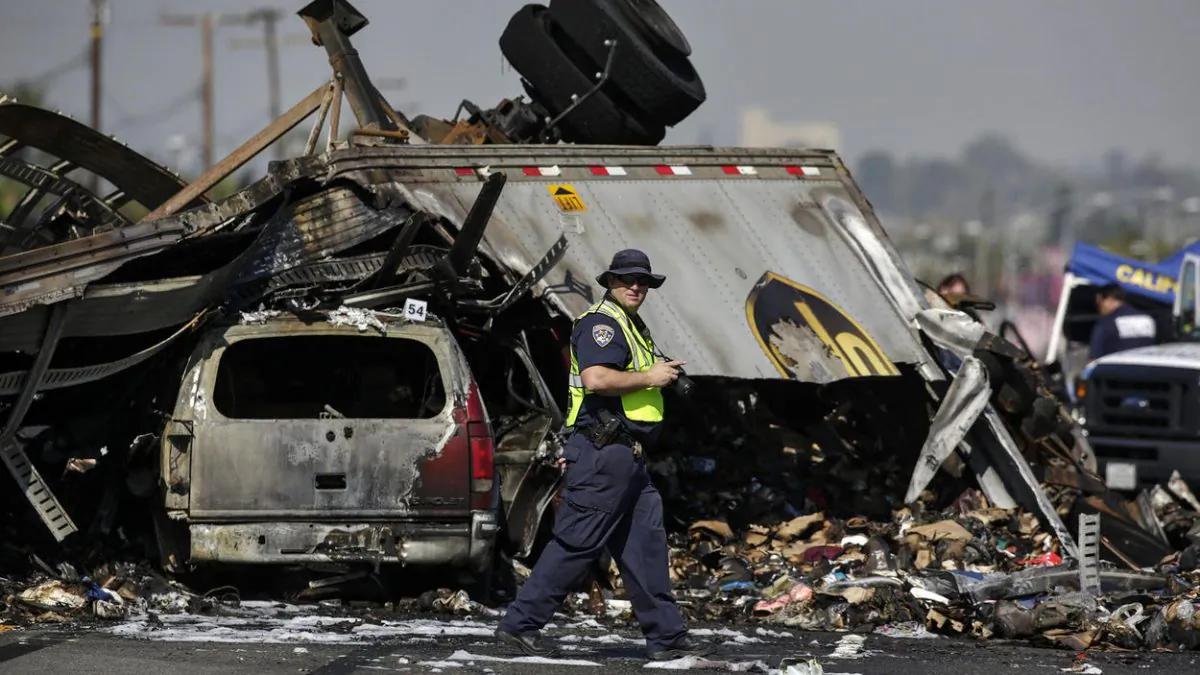 A California Highway Patrol investigator takes photographs at the scene of a multi-vehicle crash caused by drag racing on the 5 Freeway in Commerce that killed three people. (Irfan Khan/The Los Angeles Times)