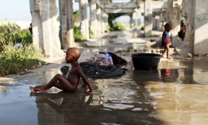 A boy bathes in a camp for individuals who have lost their homes in the Jan. 12, 2010 earthquake, in Cite Soleil, a historically impoverished area of Port-au-Prince, Haiti, on Oct. 31, 2010. (Spencer Platt/Getty Images)