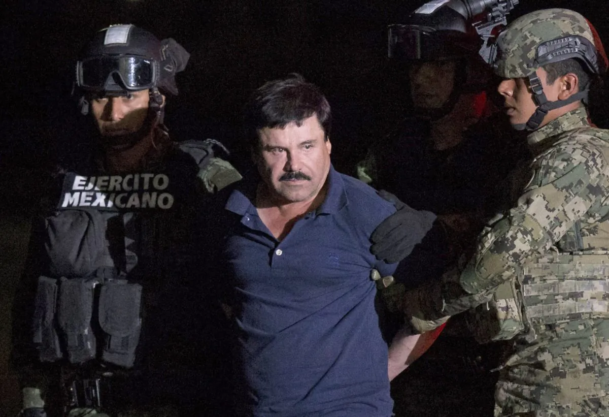 FILE - In this Jan. 8, 2016 file photo, Mexican drug lord Joaquin "El Chapo" Guzman is escorted by army soldiers to a waiting helicopter, at a federal hangar in Mexico City, after he was recaptured from breaking out of a maximum security prison in Mexico. The History channel says it's developing a drama series focusing on Guzman's story. Last year, Guzman had broken out of prison and was on the run when he had a secret meeting with Mexican actress Kate del Castillo and Sean Penn. The actor wrote about it for Rolling Stone. (AP Photo/Rebecca Blackwell, File)