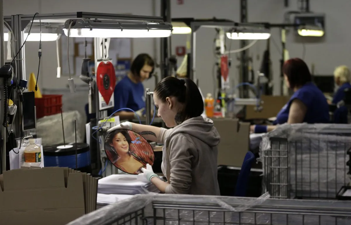 In this picture taken on Monday, April 25, 2016, worker checks a pressed record at vinyl plant in Lodenice, Czech Republic.  (AP Photo/Petr David Josek)