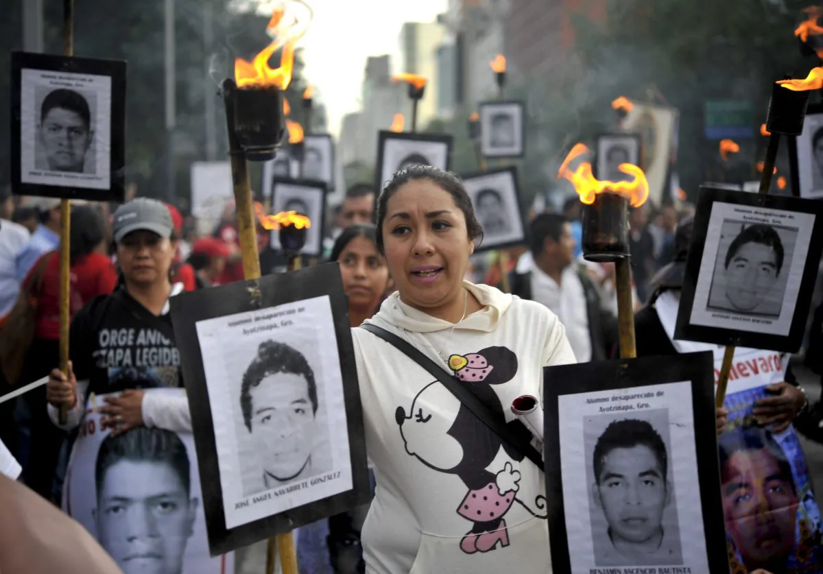 The parents of 43 missing students from the Ayotzinapa Teachers' College hold their portraits and torches during a march 18 months after their disappearance in Mexico City, Mexico, on April 26, 2016. (Yuri Cortez/AFP/Getty Images)