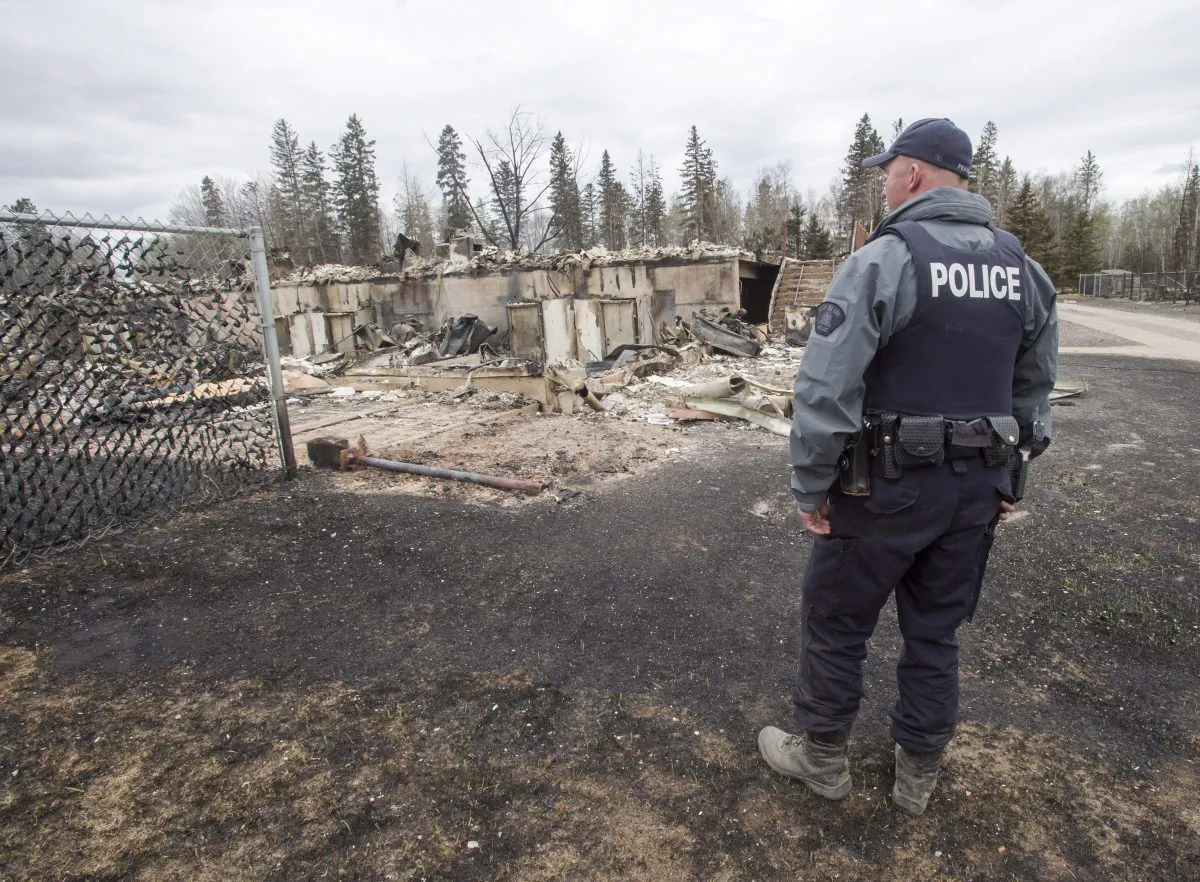 A police officer looks at the wildfire destruction in the Abasand neighbourhood of Fort McMurray on May 9, 2016. (The Canadian Press/Ryan Remiorz)