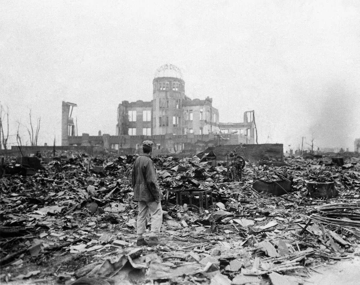 In this Sept. 8, 1945, file photo, an allied correspondent stands in the rubble in front of the shell of a building that once was a movie theater in Hiroshima, Japan, a month after the first atomic bomb ever used in warfare was dropped by the U.S. on Monday, Aug. 6, 1945. (AP Photo/Stanley Troutman, File)