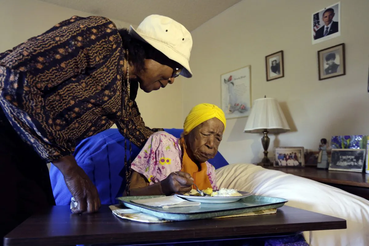 FILE - In this Monday, June 22, 2015 photo, Lois Judge, left, helps her aunt Susannah Mushatt Jones, during breakfast in Jones' room at the Vandalia Avenue Houses, in the Brooklyn borough of New York. Jones, the worlds oldest person, has died in New York at age 116. Robert Young, a senior consultant for the Gerontology Research Group, says Jones died at a senior home in Brooklyn Thursday night, May 12, 2016. He said she had been ill for the past 10 days. (AP Photo/Richard Drew, File)