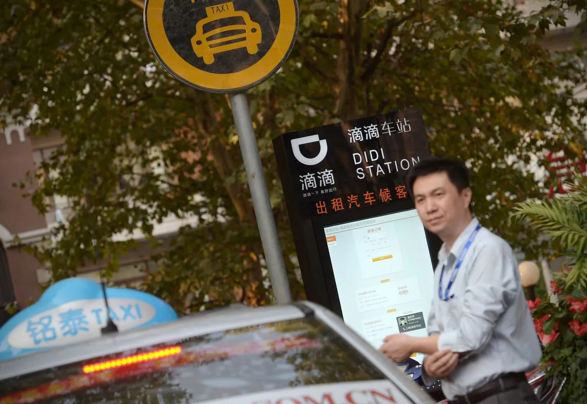 A taxi driver waits at a Didi Station, a road-side stop for taxis booked by the Chinese car-hailing app Didi Chuxing in Shanghai. (Chinatopix via AP)