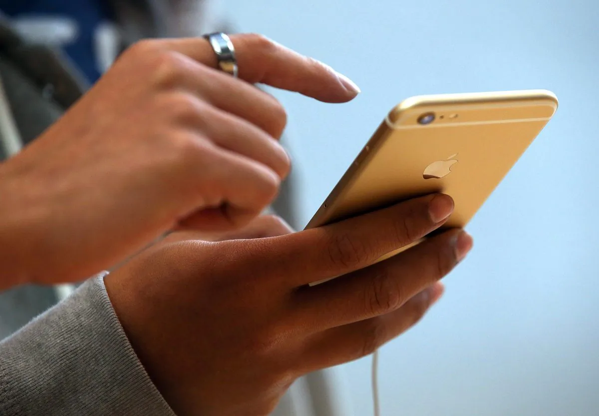 A consumer looks at an iPhone screen in Palo Alto, California. (Photo by Justin Sullivan/Getty Images)