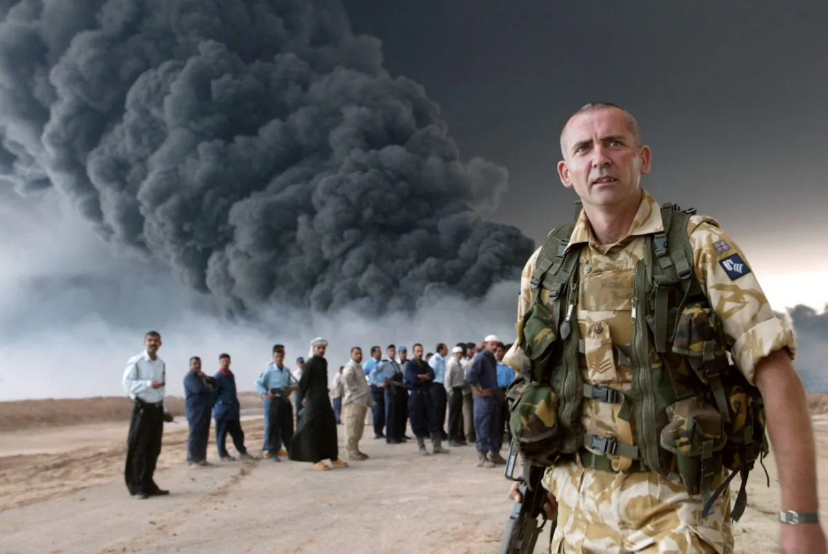 A British soldier secures an area near the burning oil export pipeline from the southern city of Basra, Iraq, March 24, 2004. (Joseph Barrak/AFP/Getty Images)