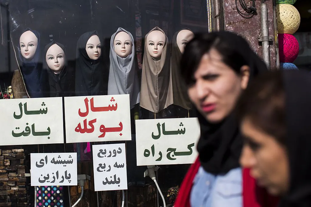 Iranian women walk past a shop displaying scarves on mannequins in downtown Tehran on February 24, 2016. (BEHROUZ MEHRI/AFP/Getty Images)