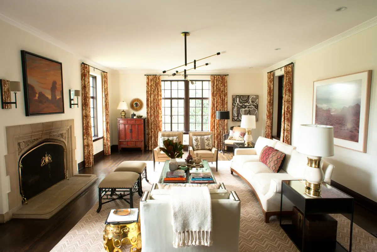A living room designed by Betsy Burnham of Burnham Design. A couple's contrasting tastes are both represented: Sleek, modern furniture and lighting mix beautifully with soft floral drapes and colourful, patterned pillows. (John Hugstad/Burnham Design via AP) 
