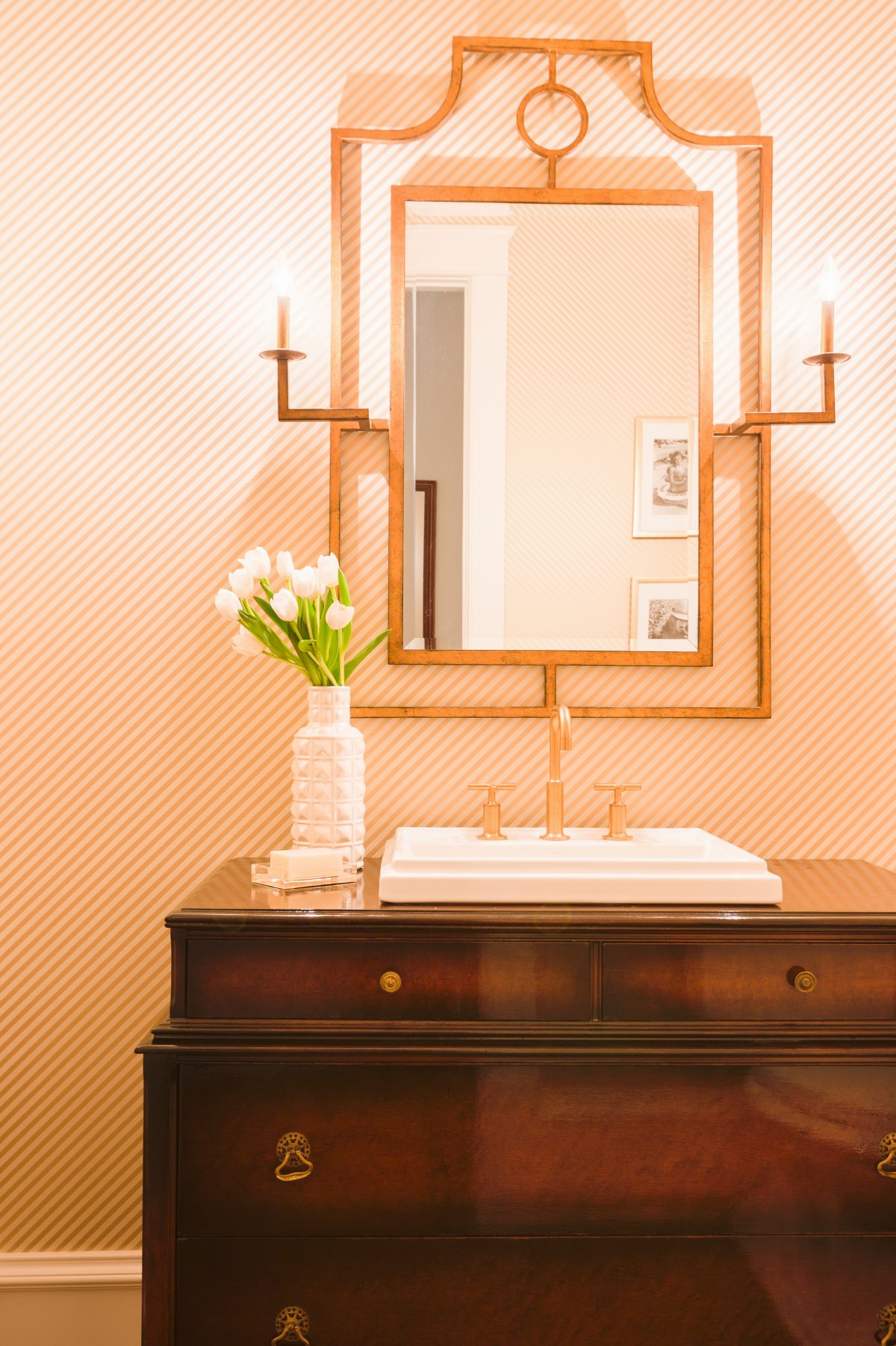 A vintage dresser that wasn't needed in a bedroom was converted into a bathroom vanity in this powder room designed by Laura Burleson Interiors. (Alyssa Rosenheck/Laura Burleson Interiors via AP) 