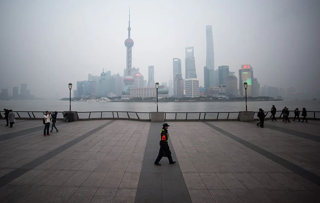A security guard walks at the bund near the Huangpu river across the Pudong New Financial district, in Shanghai on January 18, 2016. (Johannes Eisle/AFP/Getty Images)