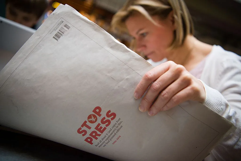 A woman poses reading a copy of the final print edition of the Independent newspaper in London on March 26, 2016. (Leon Neal/AFP/Getty Images)