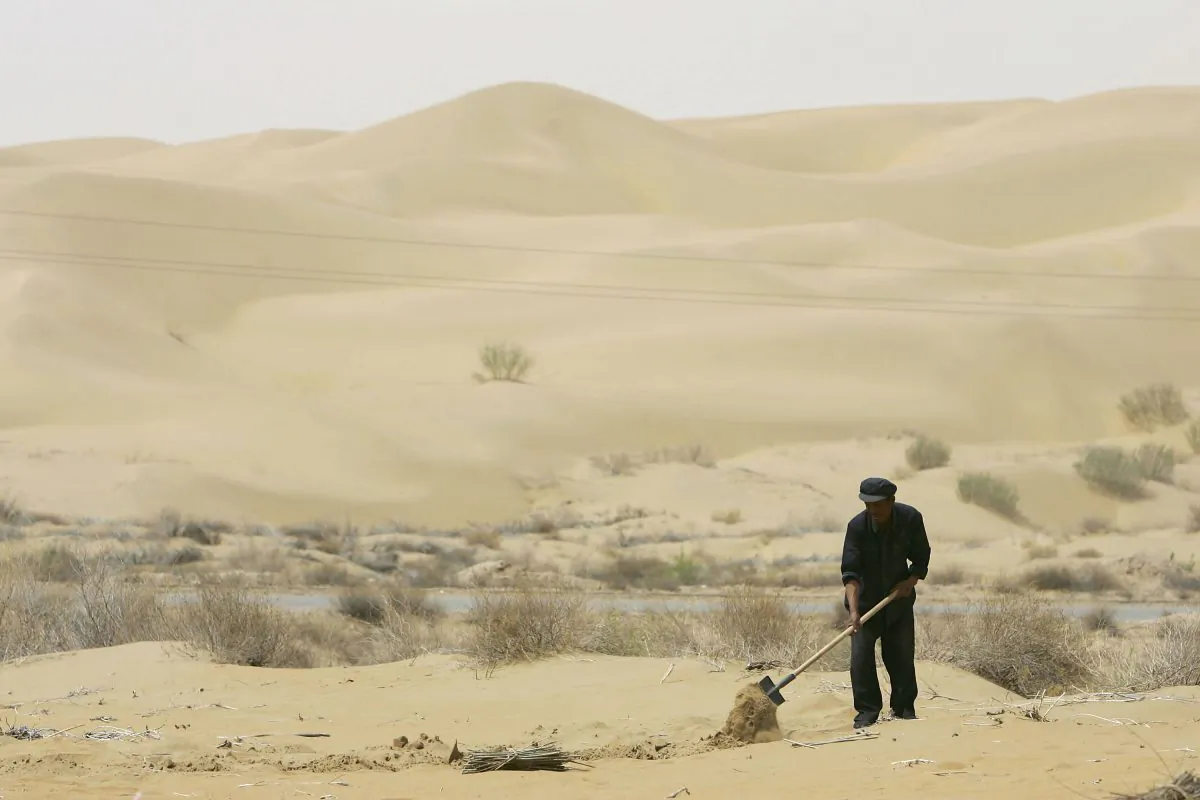 A villager plants trees to try and keep the sand from shifting to other areas in the Hobq Desert in Hangjin County, Inner Mongolia Autonomous Region, northern China, on May 5, 2006. Desertification in some western and northern regions has accelerated in recent years due to drastic water shortage, destruction of grassland resources, pollution, and other reasons, according to state media. (China Photos/Getty Images)