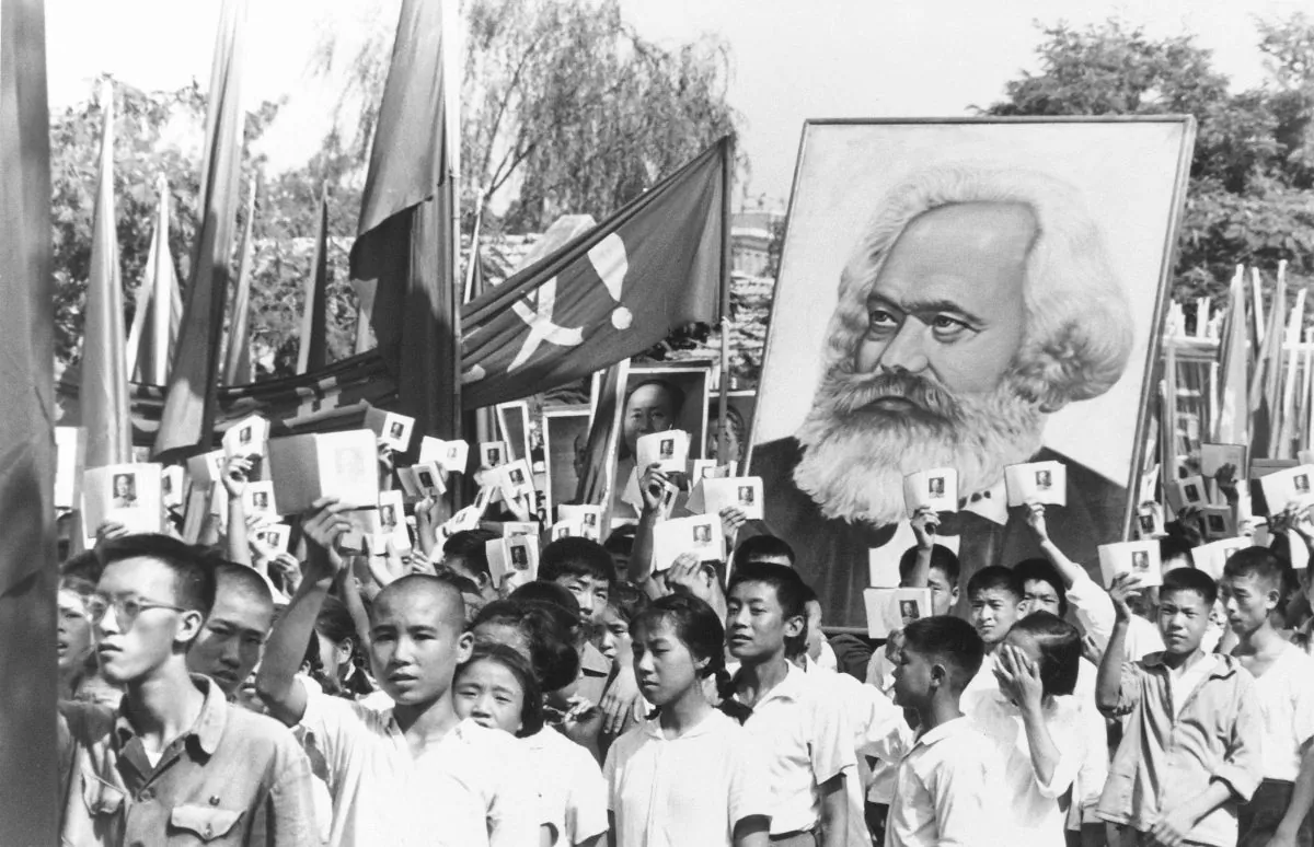 In a file photo, youths are seen at a rally during the height of the Red Guard upheaval waving copies of the collected writings of Communist Party Chairman Mao Zedong, often referred to as Mao's Little Red Book, and carrying a poster of Karl Marx. (AP Photo)
