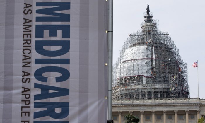 A sign supporting Medicare is seen on Capitol Hill in Washington, D.C., on July 30, 2015, as registered nurses and other community leaders celebrate the 50th anniversary of Medicare and Medicaid. Medicare spending on breakthrough medications for hepatitis C will nearly double in 2015, passing $9 billion, according to new government figures. That’s raising insurance costs for all beneficiaries, whether or not they have the liver-wasting viral disease. (AP Photo/Jacquelyn Martin)