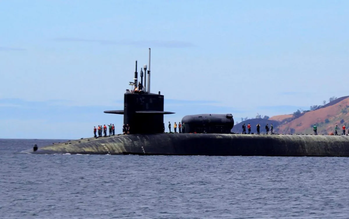 U.S. Navy crew stand on the USS Michigan (SSGN-727), an Ohio-class guided missile submarine, as it prepares to dock at Subic Freeport, a former US naval base Tuesday, March 25, 2014 about 70 kilometers (44 miles) west of Manila, Philippines. (AP Photo/Jun Dumaguing)