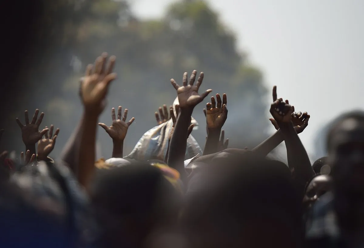 Displaced people raise their hands as they wait for food distribution, near Mpoko Bangui's airport where 100.000 people have found shelter on Jan. 8, 2014. Strife-torn Central African Republic is heading for a humanitarian disaster, a Unicef official warned, calling for urgent action to prevent deadly diseases from spreading in overcrowded refugee camps. (Eric Feferberg/AFP/Getty Images)
