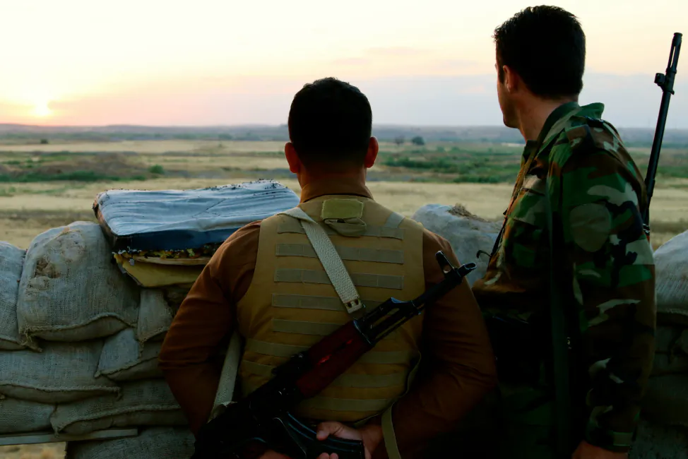 Kurdish soldiers look toward ISIS lines. (Nolan Peterson/The Daily Signal)