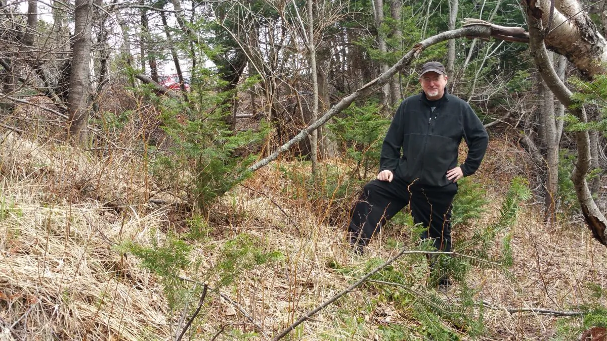 Wayne MacIsaac stands near what he believes may be the remnants of a Norse fortification wall. (Tara MacIsaac/Epoch Times)