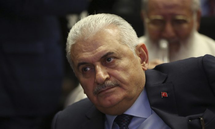 In this Thursday, May 12, 2016 photo, Binali Yildirim, Turkey's Transportation Minister and founding member of Turkey’s governing AKP party, participates in a meeting in Ankara, Turkey.  It is announced Thursday May 19, 2016, Yildirim will stand unopposed for the party leadership and thereby automatically become Prime Minister at an extraordinary meeting to be held Sunday in Ankara. The shake up comes after Prime Minister Ahmet Davutoglu stepped down on May 4.(AP Photo/Burhan Ozbilici)