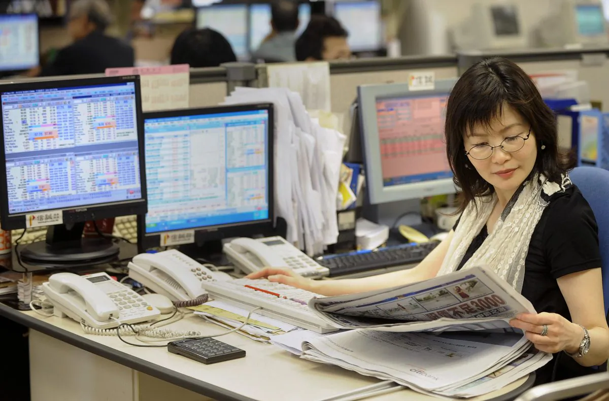 A trader reads a newspaper at a local brokerage in Hong Kong on May 5, 2009. (MIKE CLARKE/AFP/Getty Images)