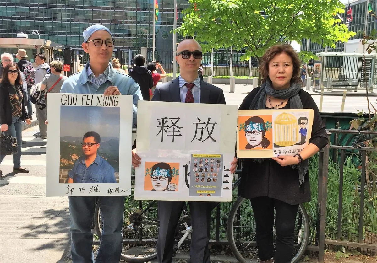 Zhong Jinhua (center) stands with Chen Shisheng, a member of Independent Chinese PEN Center who now lives in forced exile (left), and Lü Jinghua, a June 4 activist, a petitioner from Shanghai (right), on May 20, outside the United Nations Headquarters in New York City. (Eva Fu/Epoch Times)