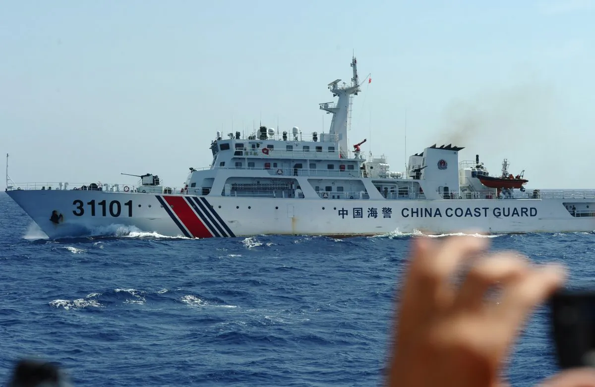 A Vietnamese coast guard officer photographs a Chinese coast guard vessel in disputed waters in the South China Sea on May 14, 2014. (Hoang Dinh Nam/AFP/Getty Images)