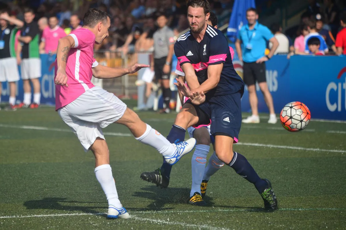 Clear and away: Yau Yee League defender (in pink) kicks the ball out of the area before Singapore Cricket Club winger can get a chance of a strike at goal during their Masters Group B match, in the HKFC Citi Soccer Sevens 2016 at Sports Road on Saturday May 21. (Eddie So)