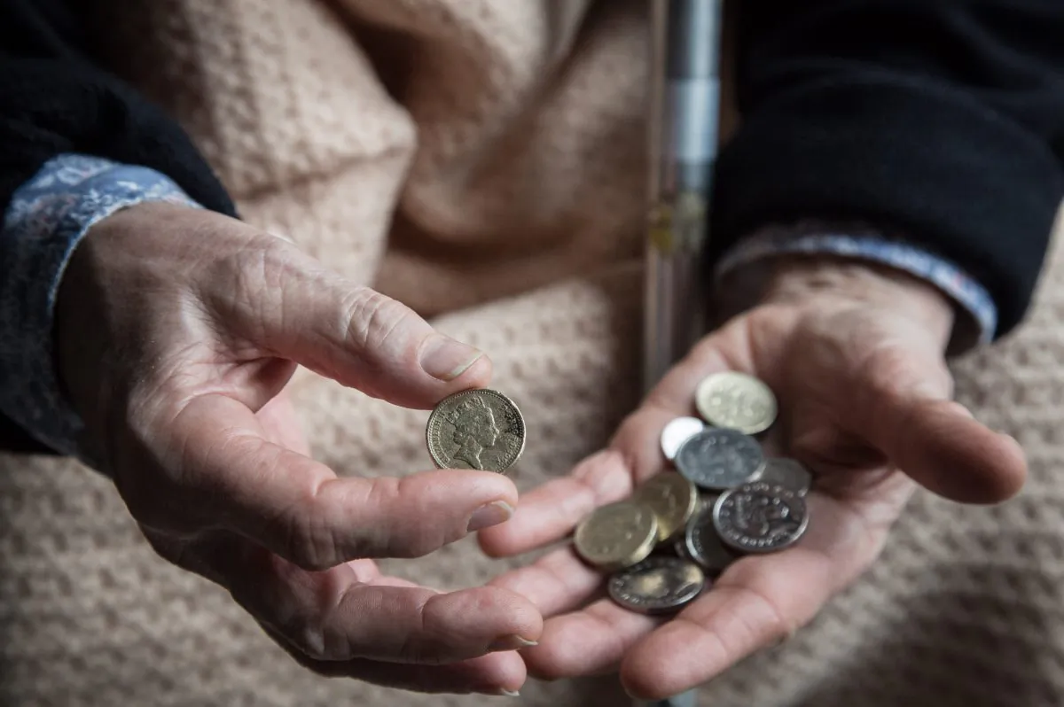 An elderly person looks at cash at home, near Bristol, England, on Feb. 16, 2015. (Matt Cardy/Getty Images)