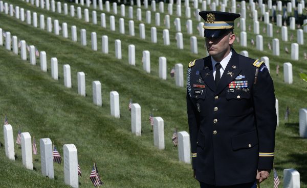 A member of the honor guard stands as the motorcade carrying U.S. President Barack Obama arrives for a Memorial Day ceremony at Arlington National Cemetery in Arlington, Va., on May 25, 2015. (Olivier Douliery/Getty Images)