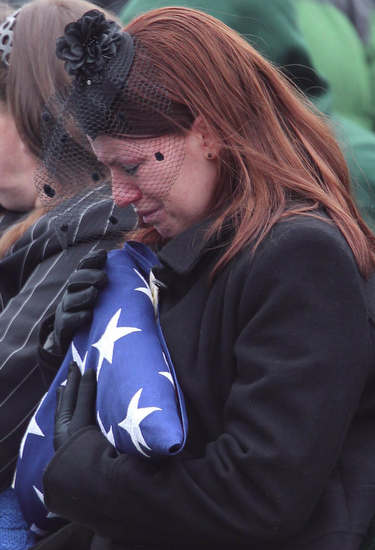 Kait Wyattt, widow of U.S. Marine Derek Wyatt, clutches the American flag which was draped over her husband's casket during funeral services at Arlington National Cemetery. (Courtesy of Arlington National Cemetery)