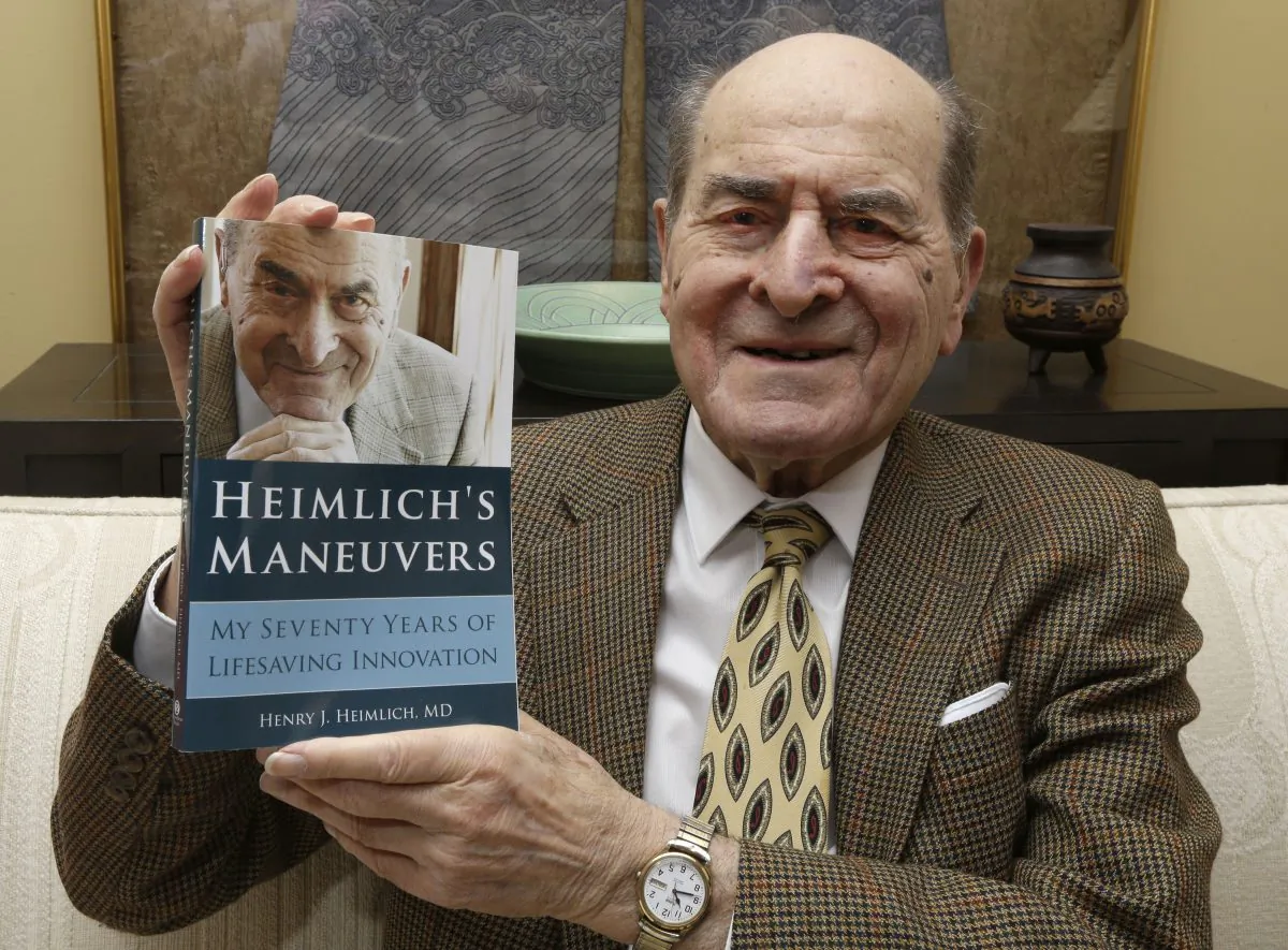 In this Wednesday, Feb. 5, 2014 photo, Dr. Henry Heimlich holds his memoirs prior to being interviewed at his home in Cincinnati. (AP Photo/Al Behrman)