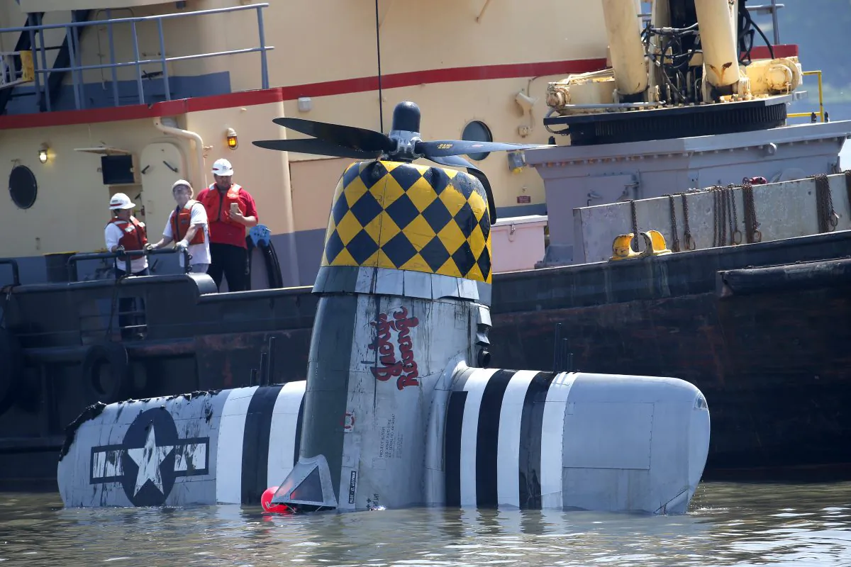 Officials remove a plane out of the Hudson River a day after it crashed, Saturday, May 28, 2016, in North Bergen, N.J. The World War II vintage P-47 Thunderbolt aircraft crashed into the river Friday, May 27, killing its pilot. (AP Photo/Julio Cortez)