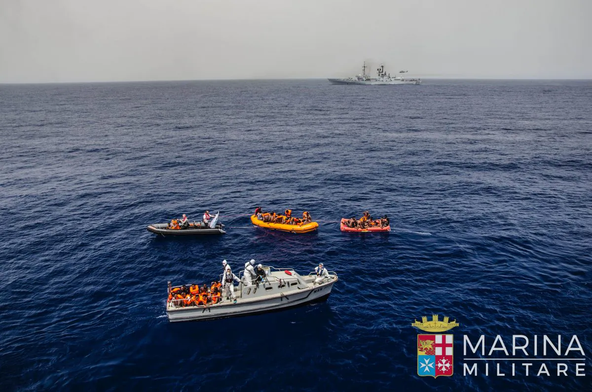 Rescuers tow migrants to board the Italian Navy ship Vega, after the boat they were aboard sunk in the Mediterranean Sea, off the Libyan coast, on May 27, 2016. (Raffaele Martino/Marina Militare via AP Photo)