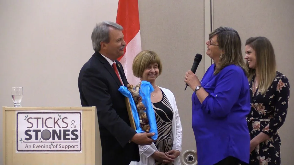 Organizer Marlene Black presents Ontario MPP Jack MacLaren with a “sticks and stones” gift at a dinner event in Kenata on May 28, 2016. MacLaren’s wife Janet is on his left, and his daughter Alexis is on the far right. (Limin Zhou/Epoch Times)
