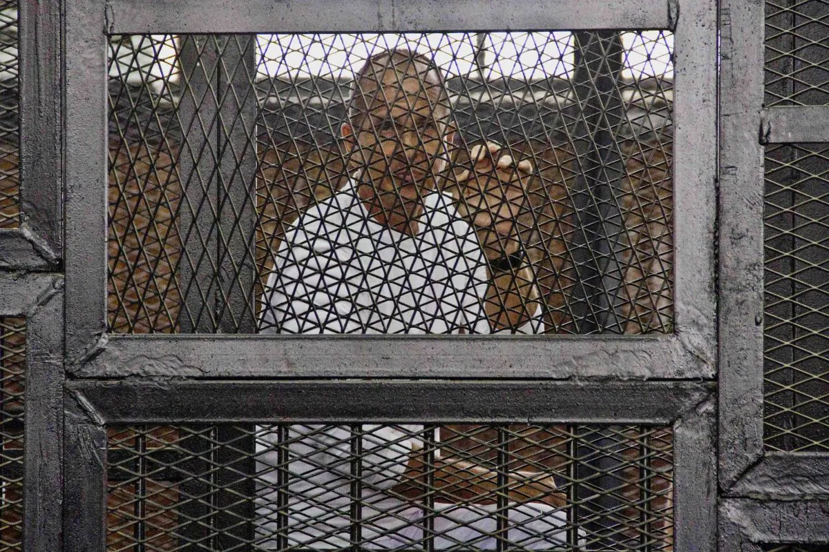 Al-Jazeera's award-winning Australian correspondent Peter Greste is in a defendants' cage in the Police Academy courthouse during a trial on aledged terror charges in Cairo, Egypt, on May 3, 2014. (AP Photo/Hamada Elrasam,)