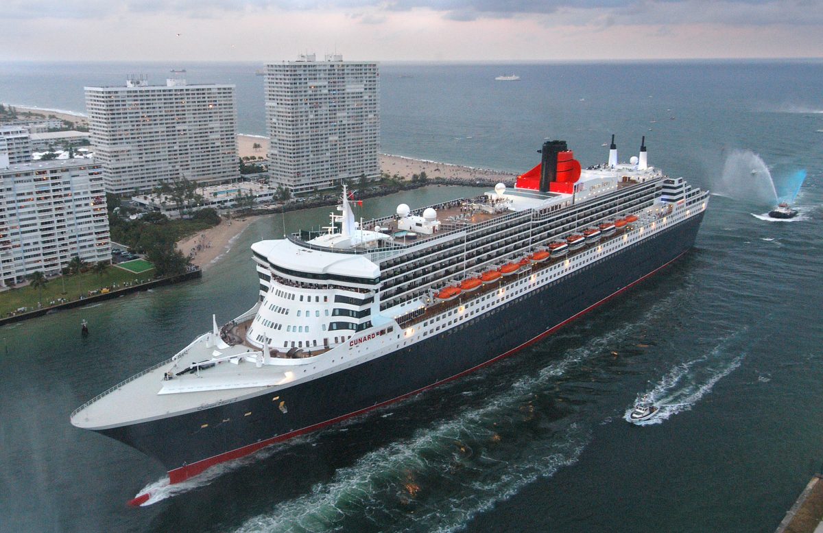 A water-squirting tugboat salutes the Queen Mary 2, the largest luxury ocean liner ever constructed, as it arrives at Port Everglades, in Fort Lauderdale, Fla., on Jan. 26, 2004, following its first trans-Atlantic voyage from Southampton, England. (Andy Newman/Cunard Line via Getty Images)