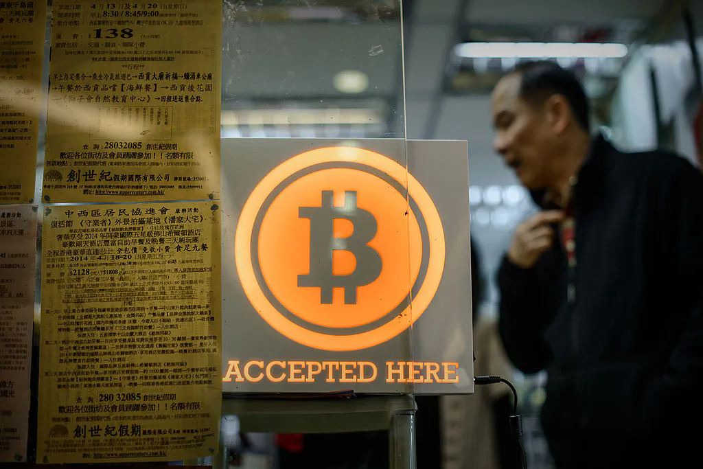A man walks out of a shop displaying a bitcoin sign during the opening ceremony of the first bitcoin retail shop in Hong Kong on February 28, 2014. (PHILIPPE LOPEZ/AFP/Getty Images)