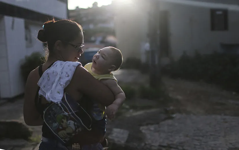 David Henrique Ferreira, nine-months-old, who was born with microcephaly, is carried by his mother Mylene as they head for the grocery store on May 29, 2016 in Recife, Brazil. (Mario Tama/Getty Images)